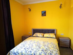a bedroom with a bed with a yellow wall at CityHaven in Ureki