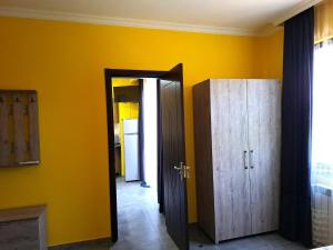 a room with yellow walls and a door and a cabinet at CityHaven in Ureki