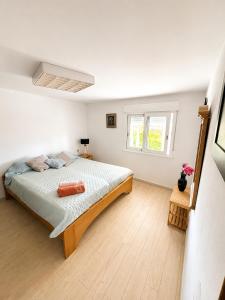 a white bedroom with a bed and a window at Apartamento As Caldelas in O Grove