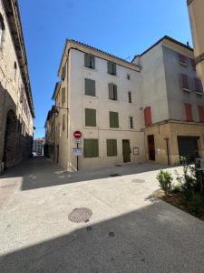 an empty street with a large white building at La Pépite du Centre Historique - 7 minutes à pied de la Gare - 1er étage - Netflix in Valence
