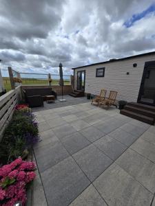 a patio with a couch and chairs and a building at PRACHTiG CHALET MEREL in Westerland