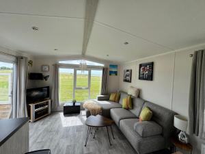 a living room with a couch and a tv at PRACHTiG CHALET MEREL in Westerland