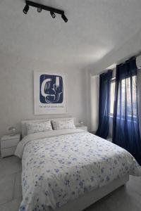 a bedroom with a large bed with blue curtains at Venera Rooms in Caltanissetta