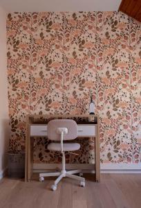 a desk with a chair in front of a wall at La VilLaye in Laye