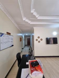 an office with a desk and a white wall at Friendly hostel in Arusha +3 photos