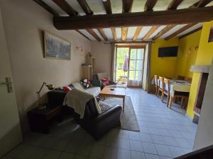 a living room with a couch and a table at Le rouge Robin in Fougax-et-Barrineuf