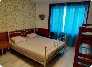 a bedroom with a bed and a blue curtain at Le nid douillet Vintage idéal pour 2 jusqu'à 4 in La Bourboule