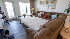 a living room with a couch and a table at Beachfront 2BR 5th Floor Views Wakable SPI in South Padre Island