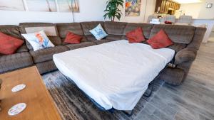 a couch with a blanket on it in a living room at Beachfront 2BR 5th Floor Views Wakable SPI in South Padre Island +170 photos
