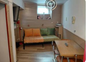 a living room with a couch and a table at Le nid douillet Vintage idéal pour 2 jusqu'à 4 in La Bourboule