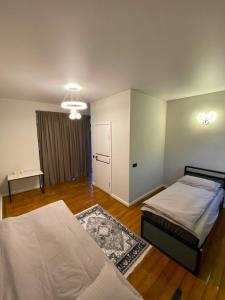 a bedroom with two beds and a table in it at Elida Guest Rooms in Cholpon-Ata
