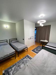 a room with two beds and a table in it at Elida Guest Rooms in Cholpon-Ata +16 photos