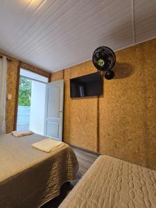 a bedroom with two beds and a fan and a window at EcoHotel Farallones in San Pedro de Jagua
