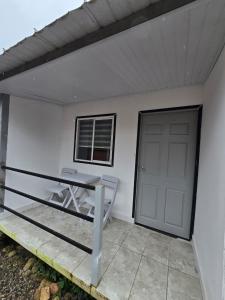 a white house with a table and a door at EcoHotel Farallones in San Pedro de Jagua