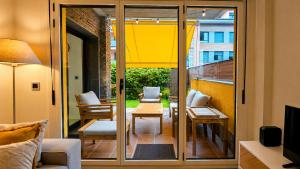 a room with a balcony with sliding glass doors at Apto Llanes Bajo con terraza - Casa Juanín in Llanes