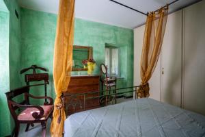 a bedroom with a bed and a mirror and a chair at Villetta Dina in Scoffera