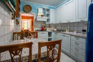 a kitchen with white cabinets and a table with chairs at Villetta Dina in Scoffera
