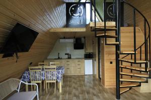 a kitchen and dining room with a spiral staircase in a house at smile cottage in Borjomi