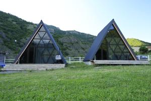 a building with two triangular roofs in a field at smile cottage in Borjomi