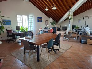 a large room with a wooden table and chairs at LAVA Açores Coliving in Ribeira Grande
