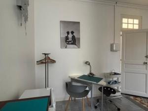 a white room with a desk and a table and chairs at Cosy studio au centre ville in Perpignan