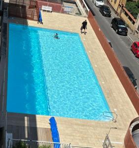 an overhead view of a large blue swimming pool at Cosy studio au centre ville in Perpignan