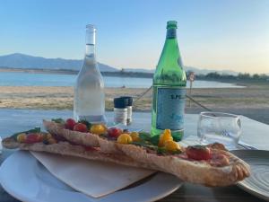 a sandwich on a table with two bottles of wine at Cosy studio au centre ville in Perpignan +9 photos