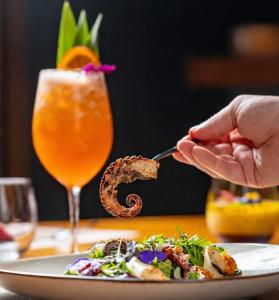 a person is eating food on a plate with a drink at Namu Garden Hotel & Spa - Adults Only in Puerto Viejo +129 photos