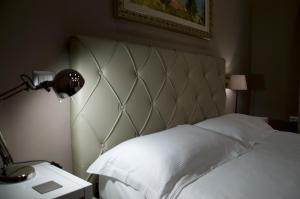 a bedroom with a white bed with a headboard and a lamp at KAIROS - Centro di Oliveto Citra in Oliveto Citra