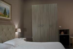 a bedroom with a white bed and a cabinet at KAIROS - Centro di Oliveto Citra in Oliveto Citra