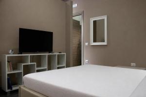 a bedroom with a bed and a flat screen tv at KAIROS - Centro di Oliveto Citra in Oliveto Citra