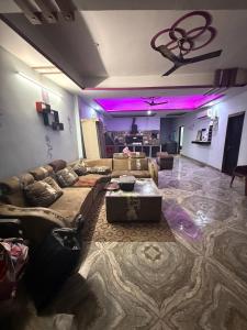a living room with a couch and purple lighting at Dixit's Villa! in Kānpur