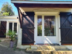 a house with a white door and a potted plant at Gîte Habas in Habas