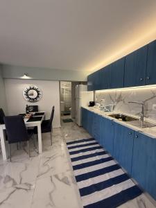 a kitchen with blue cabinets and a table with chairs at Sun & Sea in Sounio +5 photos