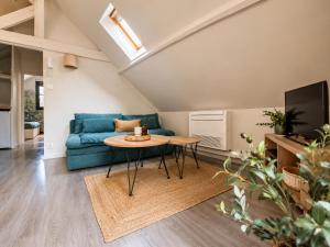 a living room with a blue couch and a table at La haute république in Brive-la-Gaillarde