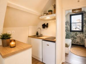 a small kitchen with a sink and a desk at La haute république in Brive-la-Gaillarde +2 photos