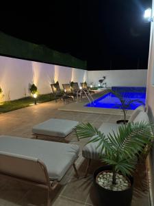 a patio with chairs and a pool at night at villa HLH in Tangier