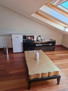 a living room with a table and a refrigerator at Casita relax Amariz Loureiro in Oya
