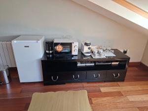 a kitchen with a counter with a microwave and a refrigerator at Casita relax Amariz Loureiro in Oya +19 photos