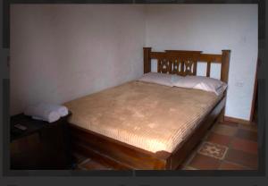 a bedroom with a wooden bed in a room at Hostal La Terraza Mirador in Jardin
