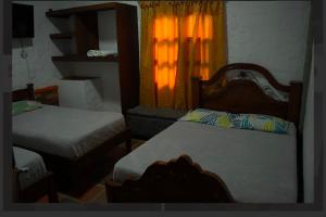 a small bedroom with two beds and a window at Hostal La Terraza Mirador in Jardin