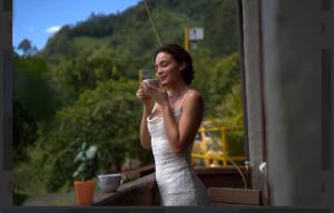 a woman in a white dress looking at her cell phone at Hostal La Terraza Mirador in Jardin