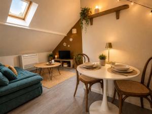 a living room with a table and a couch at La haute république in Brive-la-Gaillarde