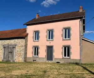 an old brick house on a grass field at Gîte de Fumouse in Le Mayet-de-Montagne