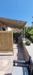 a patio with a wooden pergola and a bench at Lemnos Nest in Kondiás