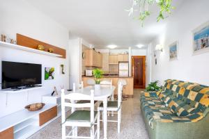 a living room with a table and a couch at Home2Book Sunny Terrace Apt, el Rincón de ManFe in Candelaria
