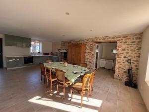 a kitchen and dining room with a table and chairs at Gîte de Fumouse in Le Mayet-de-Montagne