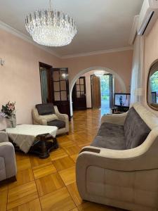 a living room with a large bed and a chandelier at Dream House in Batumi