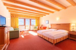 a bedroom with a bed and a television in a room at Hotel Schopfenhof in San Candido