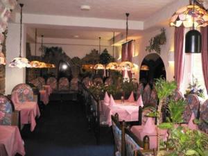 a dining room with tables and chairs with pink table cloth at Hotel Restaurant Blumenhof in Baesweiler